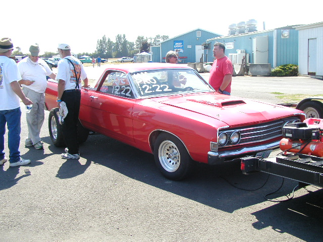 Red 1967 Ford Ranchero with racing decals on windshield