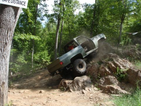 1974 Ford Bronco - A modified pickup truck navigates a challenging off-road obstacle course.