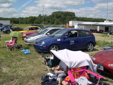2002 Ford Focus - A blue 2002 Ford Focus, number 25, is parked at an event with other vehicles.