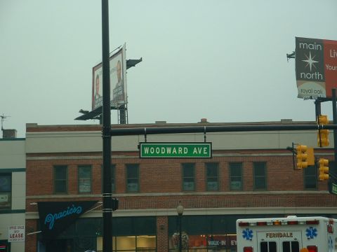 1978 Ford Mustang II - A street sign for Woodward Ave is visible above a brick building with a blue sign for Gracie's.