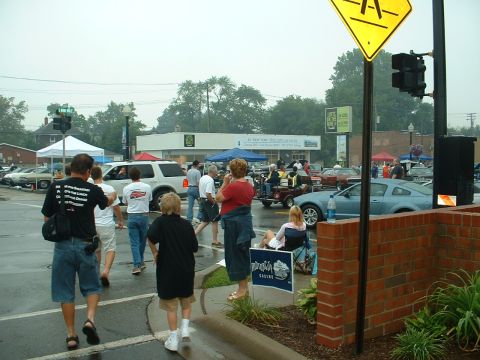 1978 Ford Mustang II - A car show event appears to be taking place on a street with several vehicles and attendees.