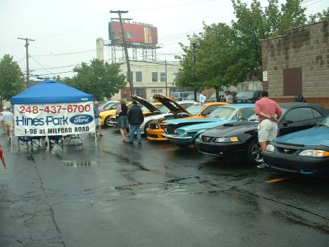 1978 Ford Mustang II - A collection of Ford Mustangs are displayed at an outdoor event, with several hoods open.