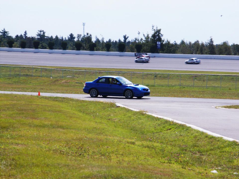 Blue sedan with number 22 on door driving on a race track