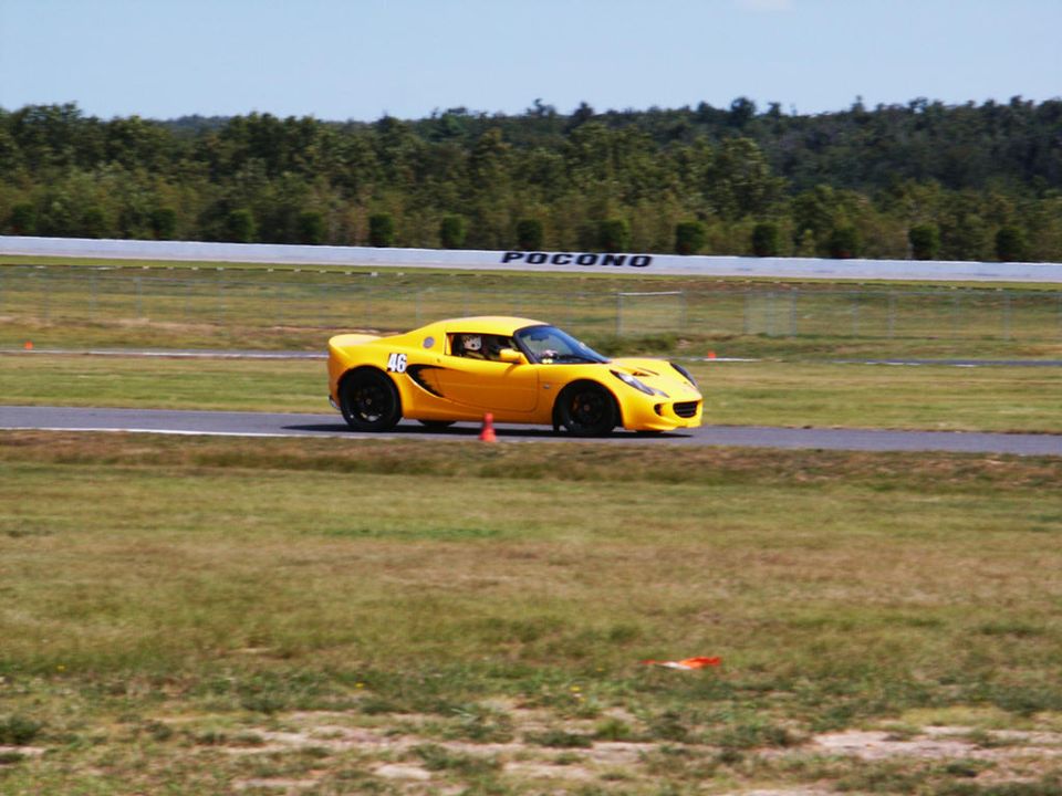 Yellow Lotus Elise on a race track with the number 46 on the door