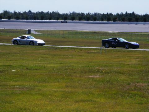 2001 Mercury Grand Marquis - Two sports cars are seen on a race track, one silver and one blue with the number 247 visible on its side.