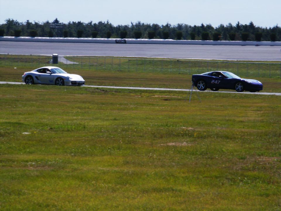 Silver sports car and blue sports car with number 247 on a race track