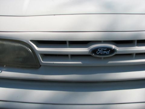 2003 Ford Crown Victoria - Front grille and headlight of a 2003 Ford Crown Victoria, showing the Ford emblem.
