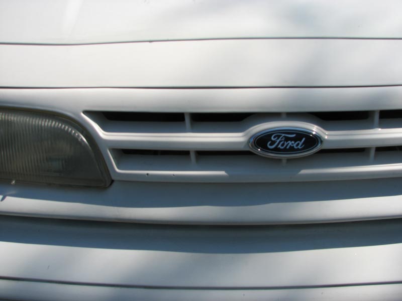 Close-up of 2003 Ford Crown Victoria grille with Ford emblem and headlight