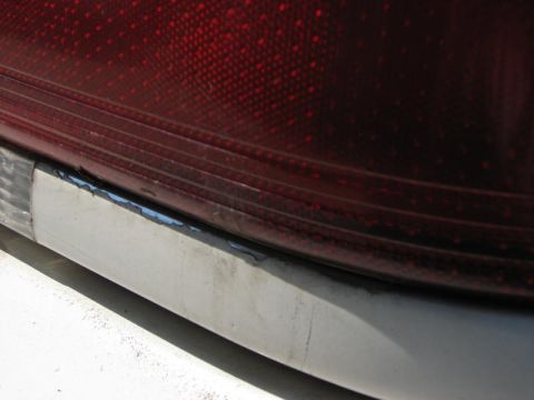 2003 Ford Crown Victoria - A close-up view of a vehicle's red taillight assembly and its chrome trim.