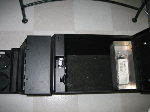1986 Ford F-150 - Center console storage compartment with a part inside a metal box.