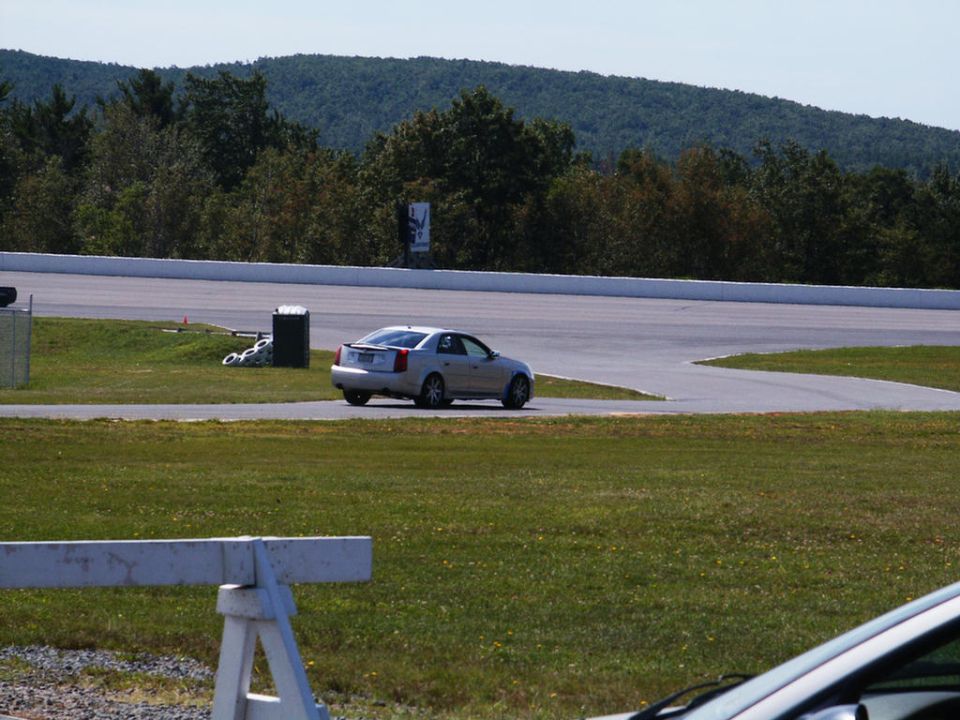 Silver Cadillac CTS on a race track, seen from the rear