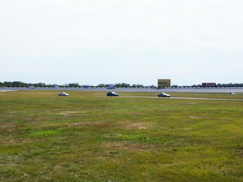 2001 Mercury Grand Marquis - Cars on a race track with a billboard in the distance.