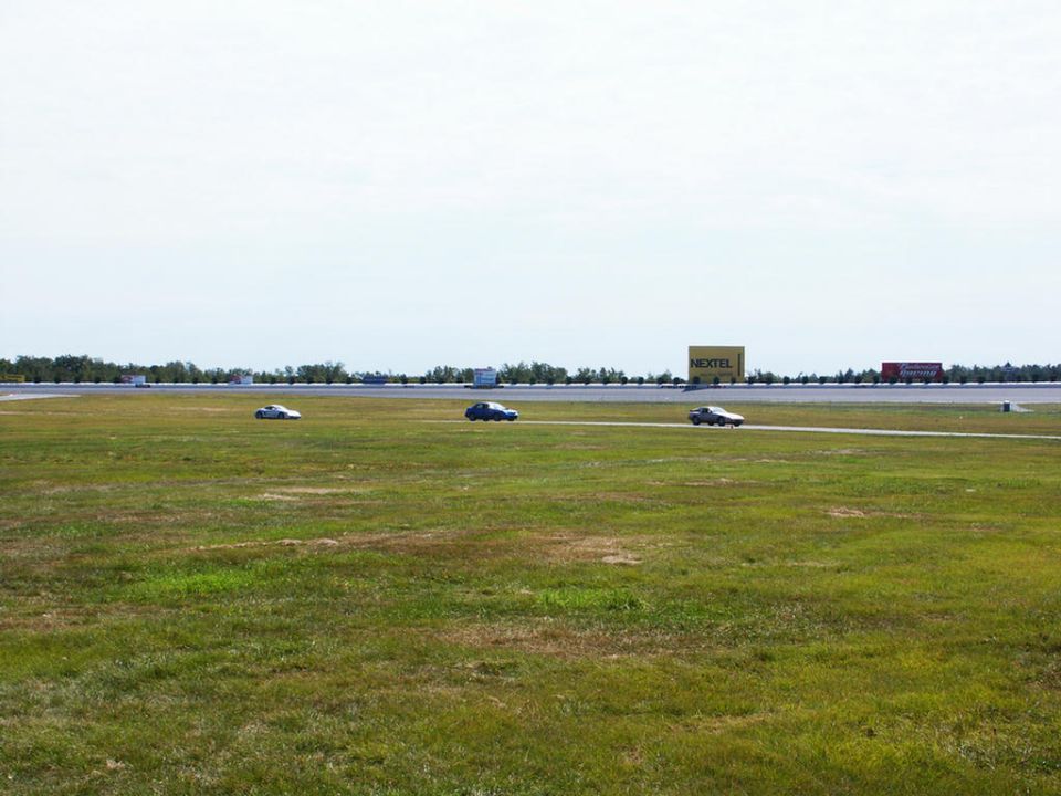 Three cars on a race track with a NEXTEL billboard in the background