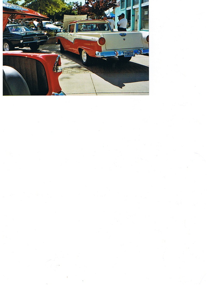 Two-tone red and cream 1957 Ford Ranchero pickup truck, rear view, parked on pavement
