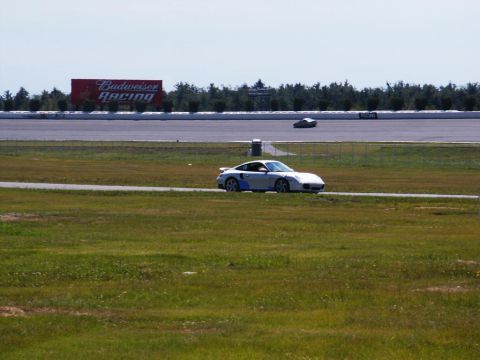 2001 Mercury Grand Marquis - A silver Porsche 911 drives on a race track, with a large Budweiser Racing billboard visible.