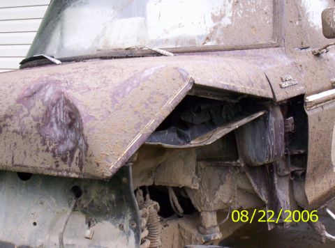 1978 Ford F-150 - Front fender and wheel well of a 1978 Ford F-150 are heavily damaged and caked in mud.