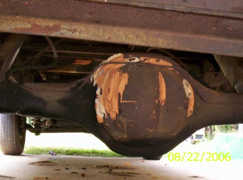 1978 Ford F-150 - Close-up of a vehicle's rear axle housing, showing significant wear and damage to the paint.