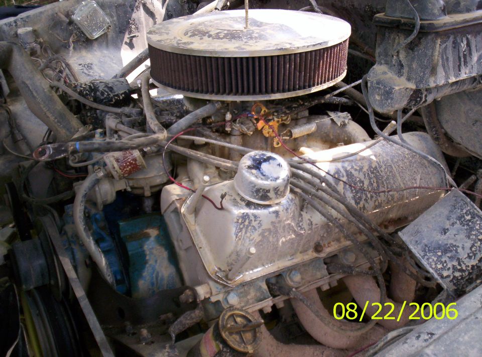 Engine bay with large round air cleaner, distributor cap, and various hoses and wires. Date stamp 08/22/2006