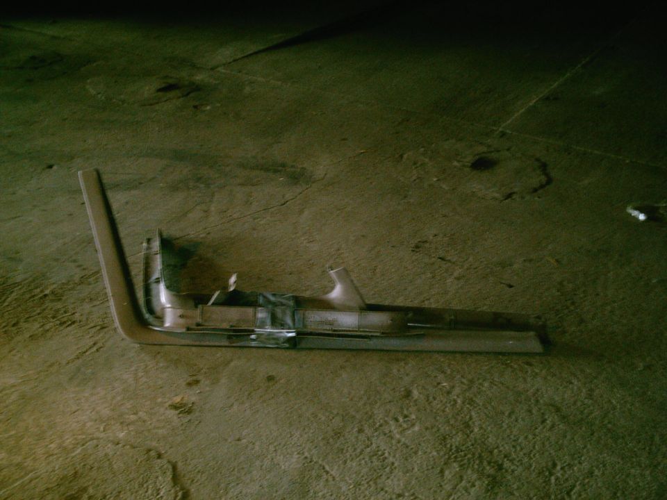 Chrome trim piece with black tape on concrete floor