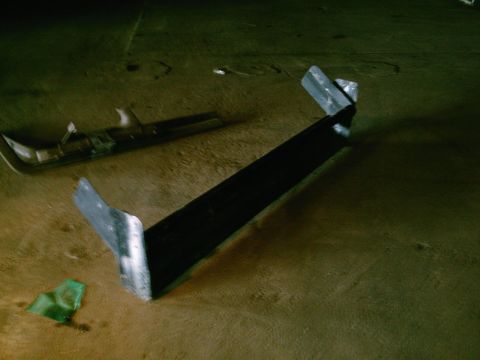 2001 Dodge 2500 - A detached vehicle part lies on a wooden surface, with another piece in the background.