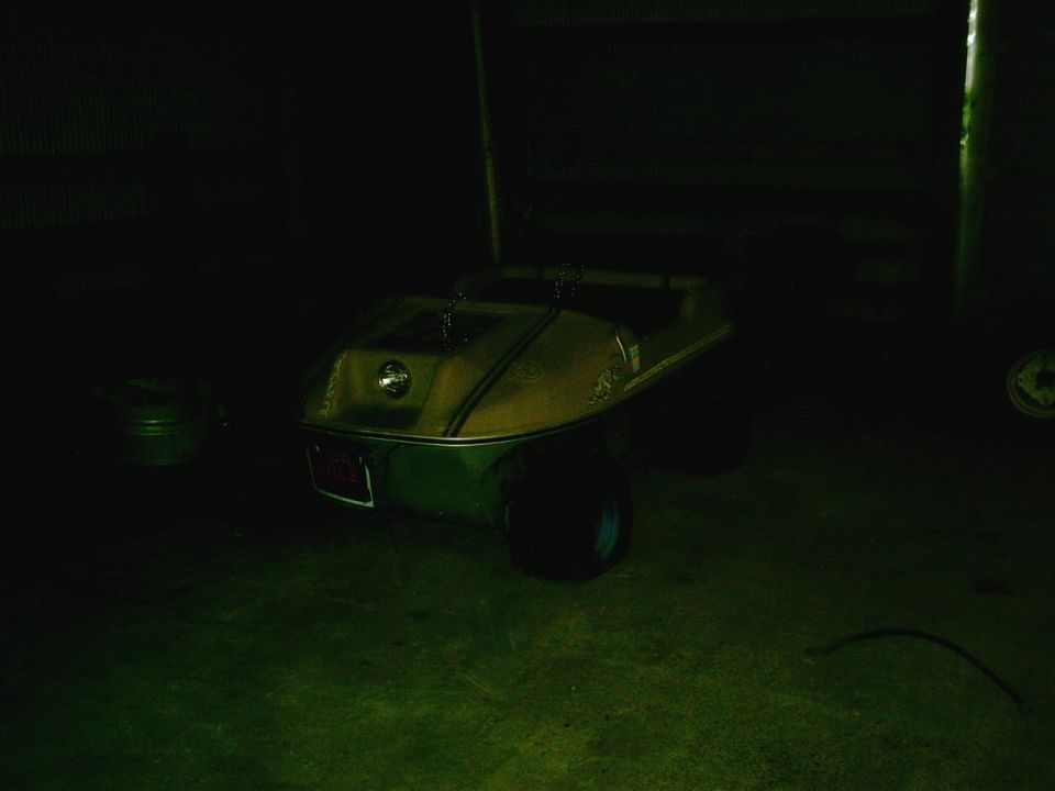 Golf cart with yellow and green body, red license plate