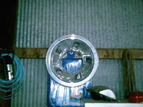 2001 Dodge 2500 - A single silver hubcap is displayed against a corrugated metal wall.