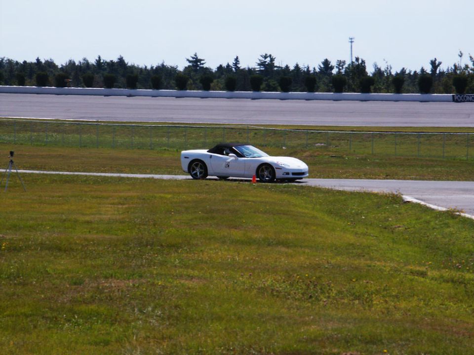 White convertible sports car on a race track, side view