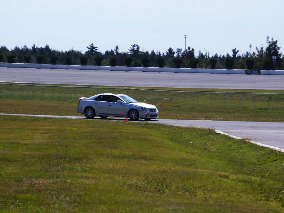 Silver Cadillac CTS on a race track, number 5 on the door