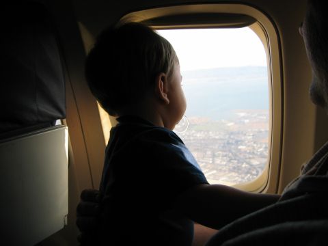 2002 Ford Taurus - A child gazes out an airplane window at the landscape below.