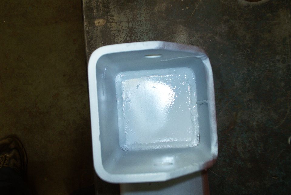 Close-up of a square metal bracket, painted light gray