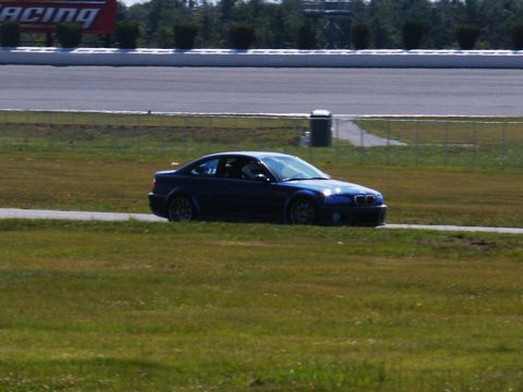 2001 Mercury Grand Marquis - A blue coupe is on a racetrack, with a sign in the background that reads 'ACING'.