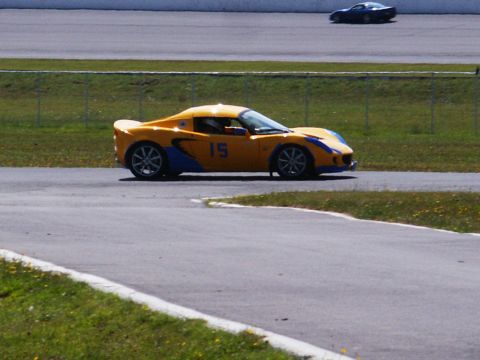 2001 Mercury Grand Marquis - A yellow and blue sports car, marked with the number 15, races on a track with another car in the background.