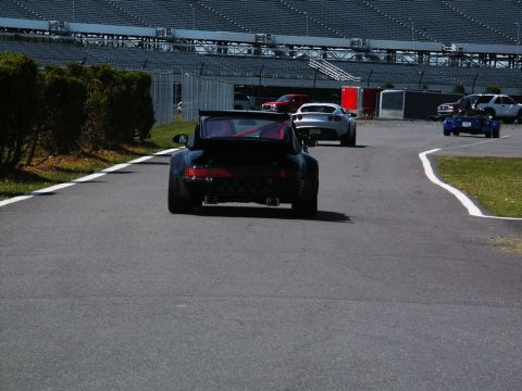 2001 Mercury Grand Marquis - Multiple sports cars are seen on a race track during an event.