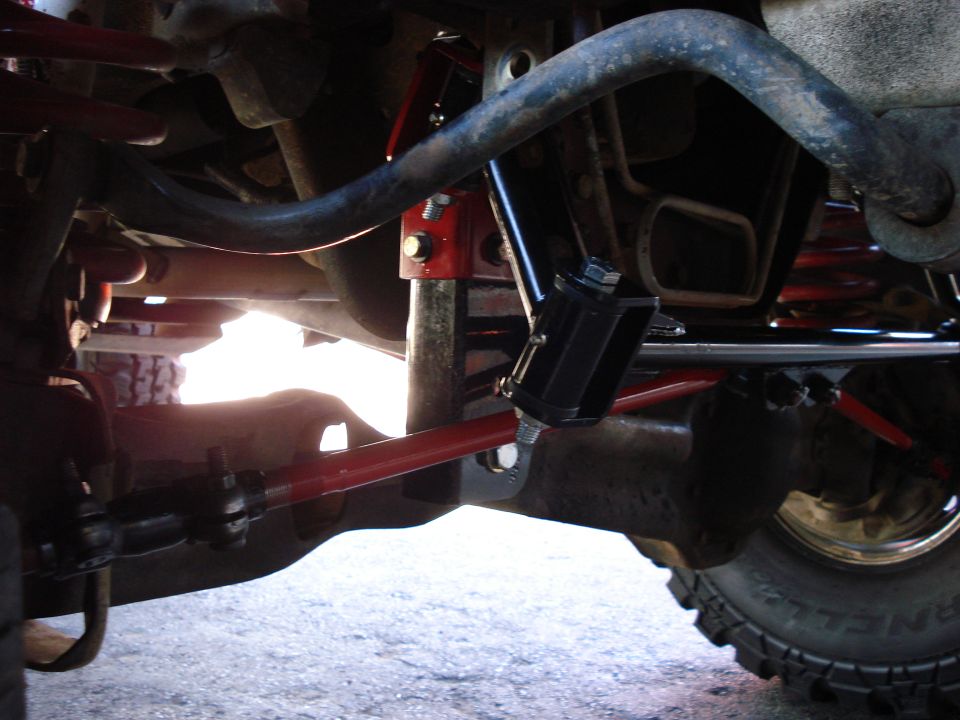 Close-up of red and black suspension parts on a vehicle's undercarriage