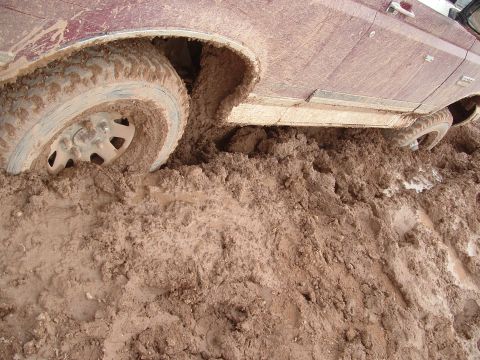 1990 Ford Bronco - This 1990 Ford Bronco is deeply stuck in thick mud, with its front wheel almost completely covered.