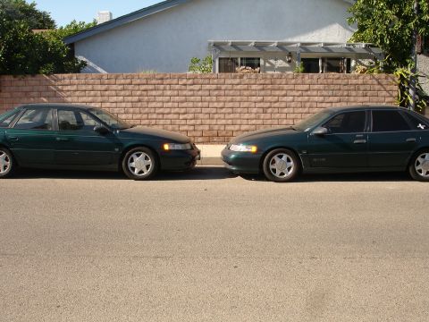 1995 Ford Taurus - Two 1995 Ford Taurus sedans are parked side-by-side on a residential street.