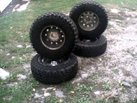 1996 Ford Bronco - Four large off-road tires are stacked on the ground, with a watermark for Supermotors.net visible.