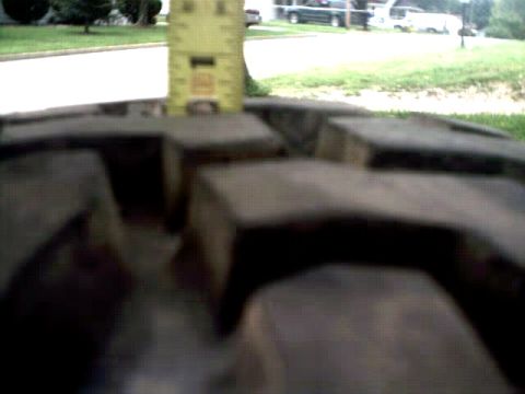 1996 Ford Bronco - Measuring tire tread depth with a yellow tape measure.