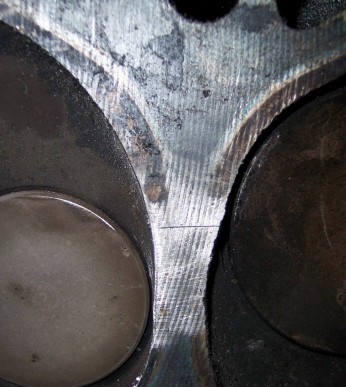 1972 Ford Ranchero - Detail of an engine's cylinder head, revealing two valves and the surrounding metalwork.