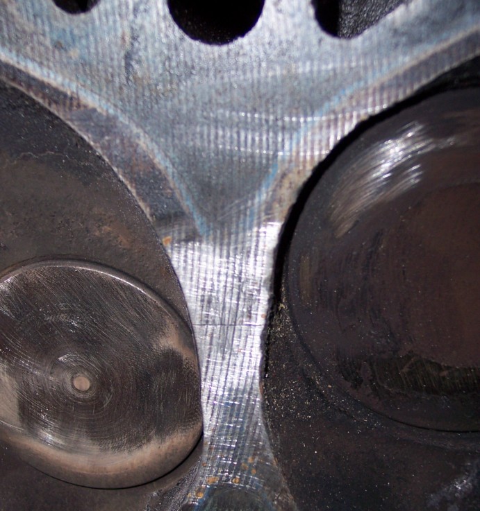 Close-up of machined cylinder head combustion chamber with carbon-stained valves