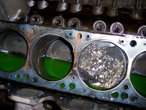 1972 Ford Ranchero - Close-up view of engine cylinders, some containing green liquid, others showing signs of damage and debris.