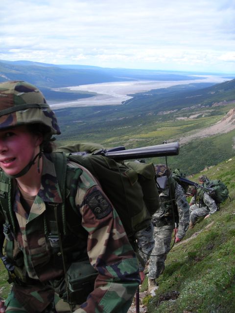 2003 Jeep TJ - A group of soldiers traverses a mountainous terrain, their gear packed for a trek through the wilderness.