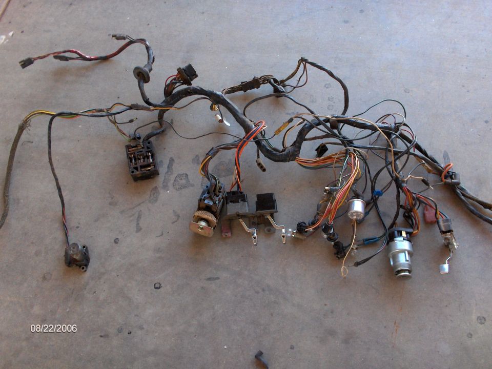 Factory dash wiring harness with fuse block and switches laid out on concrete