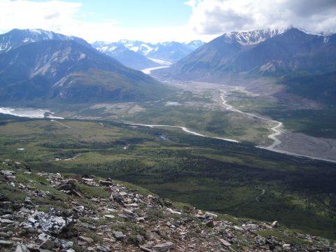 2003 Jeep TJ - A wide mountain valley landscape with a river flowing through it, seen from a rocky vantage point.