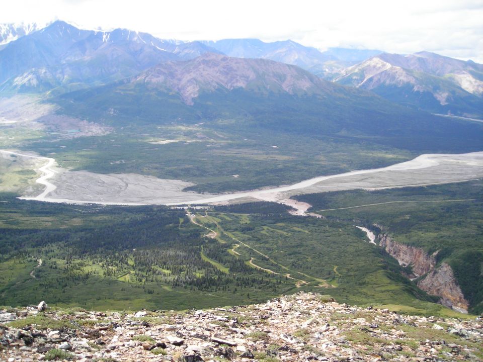 Mountain landscape with a winding river and a deep canyon under a cloudy sky