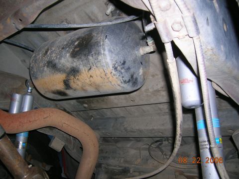 1985 Ford Bronco - Close-up view of the undercarriage, showing an air tank, exhaust system, and suspension components.