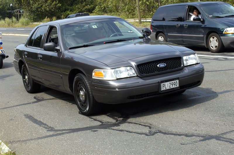 Dark gray Ford Crown Victoria with black steel wheels and a license plate reading PL 2990