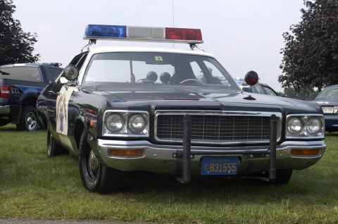 1978 Dodge Monaco - This 1978 Dodge Monaco police car features a classic light bar and a California license plate, seen parked on grass with other vehicles in…