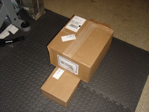 1990 Ford Bronco - Cardboard boxes with shipping labels sit on a textured mat.