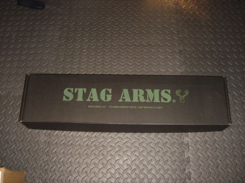 1990 Ford Bronco - A black box with "STAG ARMS" printed in green lettering, along with a deer logo and company address.